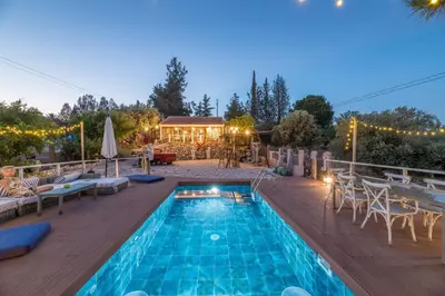 a pool with chairs and a table and a house at Rozana House in Silikou