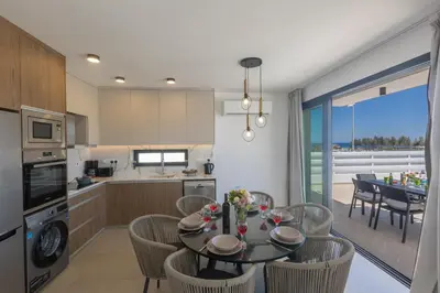 a kitchen and dining room with a table and chairs at Trinity Villa in Paralimni