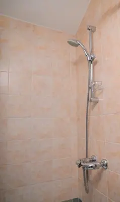 a shower with a shower head in a bathroom at Kakopetria's Holiday House in Kakopetria