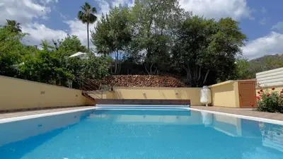 a swimming pool in a backyard with a fence and trees at Kakopetria's Holiday House in Kakopetria