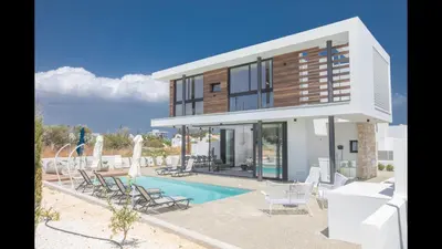 a villa with a swimming pool and lounge chairs at Protaras Elite Pearl Villa Ep17 in Protaras
