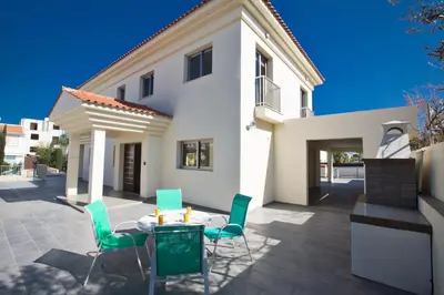 a patio with a table and chairs in front of a house at Protaras Holiday Villa Dv1 in Protaras