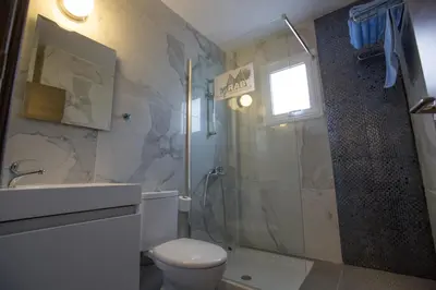 a bathroom with a shower and a toilet and a sink at Ayia Napa Holiday Apartment So3 in Ayia Napa