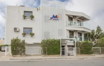 a white building with a sign on the side of it at Ayia Napa Holiday Apartment So3 in Ayia Napa