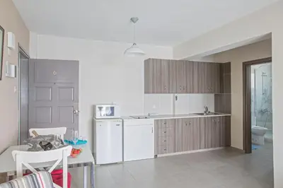 a kitchen with a white refrigerator and a table at Ayia Napa Holiday Apartment So6 in Ayia Napa