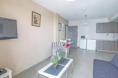 a living room with a couch and a kitchen at Ayia Napa Holiday Apartment So6 in Ayia Napa