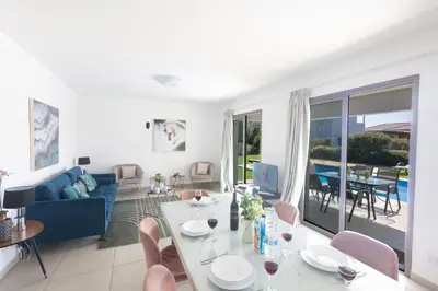 a living room with a blue couch and a table at Ayia Napa Holiday Villa Svd2 in Ayia Napa