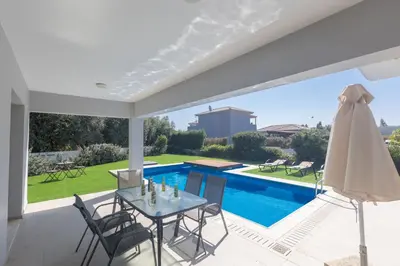 a patio with a table and chairs and a pool at Ayia Napa Holiday Villa Svd2 in Ayia Napa