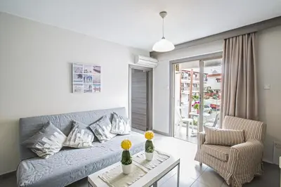 a living room with a couch and a chair at Ayia Napa Holiday Apartment So8 in Ayia Napa