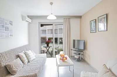a living room with a couch and a tv at Ayia Napa Holiday Apartment So1 in Ayia Napa