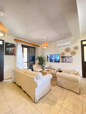 a living room with white couches and a table at Pervolina countryside by the sea in Pervolia