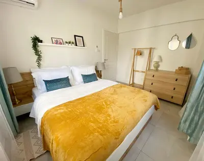 a bedroom with a large bed with a yellow blanket on it at Peaceful 2 bedroom Flat in Engomi