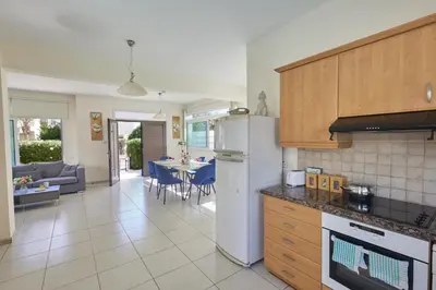 a kitchen with a refrigerator and a living room at Protaras Holiday Villa Dv27 in Protaras