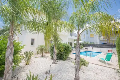 a villa with a swimming pool and palm trees at Protaras Delfini Villa Dv4 in Protaras