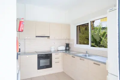 a white kitchen with a sink and a window at Protaras Delfini Villa Dv4 in Protaras