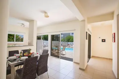 a dining room and living room with a table and chairs at Protaras Delfini Villa Dv8 in Protaras