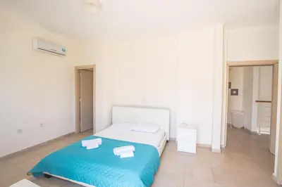 a white bedroom with a bed and a blue blanket at Protaras Delfini Villa Dv8 in Protaras