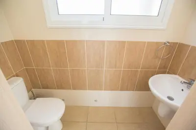 a bathroom with a toilet and a sink and a window at Protaras Delfini Villa Dv8 in Protaras