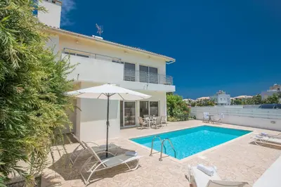 a villa with a swimming pool and an umbrella at Protaras Delfini Villa Dv8 in Protaras