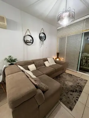 a living room with a brown couch and a window at Carisa Holiday rooms in Larnaka