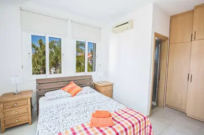 a bedroom with a bed and two windows at Villa Mesogeios ME25 in Protaras
