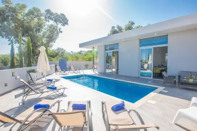 a patio with chairs and a swimming pool at Villa Polymnia Protaras 1 in Protaras