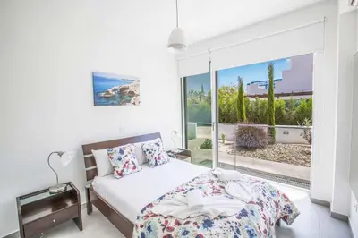 a bedroom with a bed and a large window at Protaras Greco Villa CCV2 in Protaras