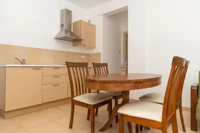 a kitchen with a wooden table and chairs at Flora Hotel Apartments in Protaras
