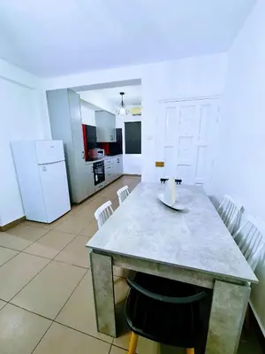 a kitchen with a table and white appliances at Ayia Anna Apartment in Ayia Napa