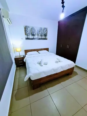 a bedroom with a large bed with white sheets at Ayia Anna Apartment in Ayia Napa