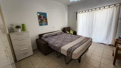 a bedroom with a bed and a dresser and a window at Ayia Napa sea view great location bars & beach in Ayia Napa