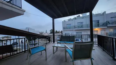 a balcony with two chairs and a table and a building at Ayia Napa sea view great location bars & beach in Ayia Napa
