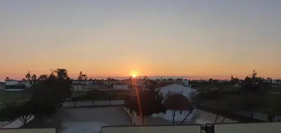 a sunset over a city with the sun setting at Sunset Sea View Villa in Ayia Napa