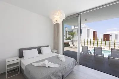 a bedroom with a bed and a balcony at Protaras Olivine Villa Ol9 in Protaras