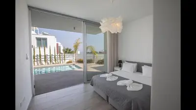 a bedroom with a bed and a swimming pool at Protaras Olivine Villa Ol10 in Protaras