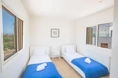 two beds in a room with two windows at Protaras Holiday Villa Dv16 in Protaras