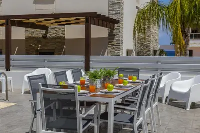 a wooden table and chairs on a patio at Protaras Sunrise Beach Villa 2 in Protaras
