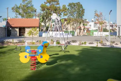 a playground with a swing in the grass at The Quality Lodge - Self Check-in in Voroklini