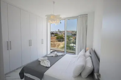 a bedroom with a bed with a large window at Protaras Olivine Villa Ol13 in Protaras