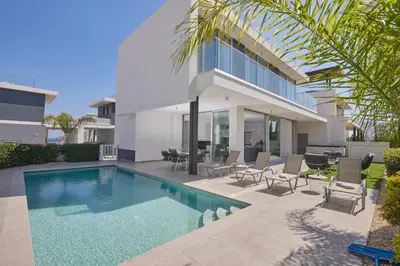 a house with a swimming pool in front of a house at Protaras Olivine Villa Ol13 in Protaras