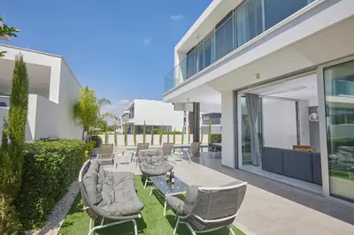 a patio with chairs and a table in front of a building at Protaras Olivine Villa Ol13 in Protaras