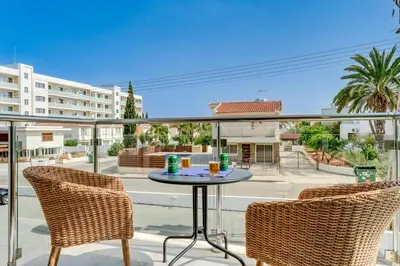a patio with two chairs and a table on a balcony at Coralli Spa Resort Protaras Stylish 1 Bedroom apartment in Protaras