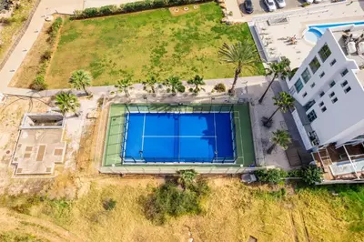 an overhead view of a large swimming pool with palm trees at Coralli Spa Resort Protaras Stylish 1 Bedroom apartment in Protaras
