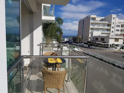a balcony with a table and chairs on a building at Coralli Spa Resort Protaras Stylish 1 Bedroom apartment in Protaras