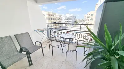 a balcony with chairs and a table on a balcony at Modern Retreat: 2br Stylish Apt with Comfy Rooms! Smart TV with 200MBPS Internet in Larnaka
