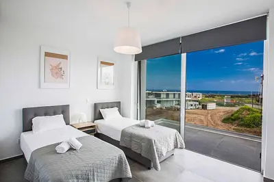 a bedroom with two beds and a large window at Villa Olivine Pearl 6 in Protaras