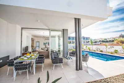 a living room with a table and chairs and a pool at Olivine Pearl OL20 in Protaras