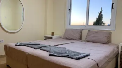 a bed with a blanket on it with a mirror at Moonlight Sea View Villa in Ayia Napa