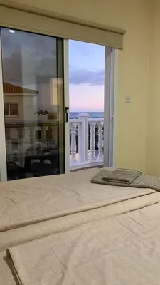 a bedroom with a bed with a view of a balcony at Moonlight Sea View Villa in Ayia Napa