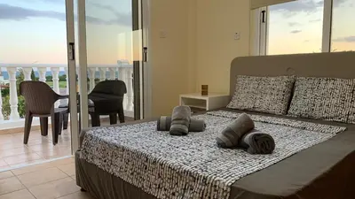 a bedroom with a bed with pillows and a balcony at Moonlight Sea View Villa in Ayia Napa